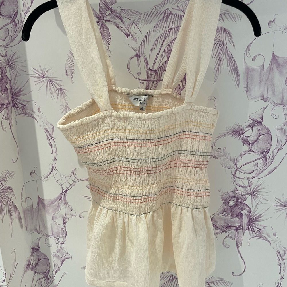 Cream smocked top with rainbow stitching with ruffle bottom
